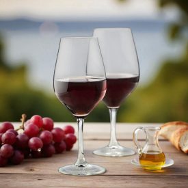 „Ribier borospoharak vörösborral mediterrán teraszon, naplementében, szőlővel és kenyérrel.”