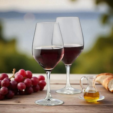 „Ribier borospoharak vörösborral mediterrán teraszon, naplementében, szőlővel és kenyérrel.”