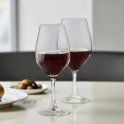 „Ribier borospoharak vörösborral modern bisztróasztalon, hangulatos vacsora közben.”