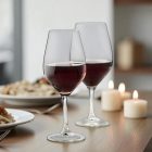 „Ribier borospoharak otthoni vacsoraasztalon, vörösborral, gyertyafényes hangulatban.”