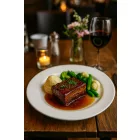 Italia 23 cm-es fehér porcelán lapostányéron szaftos sertésoldalas burgonyapürével és zöldségekkel, elegáns éttermi tálalásban