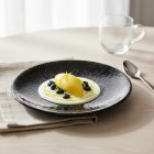 Sötét Vida Night porcelán tányér citromos desszerttel és világos öntettel, modern fine dining stílusban