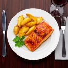 „Basic 26 cm-es fehér porcelán tányér elegáns éttermi tálalásban, lazaccal és sült burgonyával.”