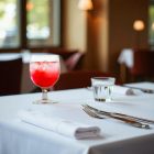 „Stack koktélos kehely 250 ml piros gyümölcskoktéllal, elegáns éttermi tálalásban, fehér abroszon.”