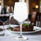 Platine vörösboros pohár 580 ml – elegáns asztalon, gyertyafényes vacsorán, félig töltve vörösborral, fine dining stílusban tálalva