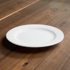 BOJ fehér porcelán menüs tányér 23 cm terítékben – esztétikus, letisztult asztali kompozíció természetes fényben