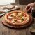Kerek akácfa tálalódeszka pizza tálalásához éttermi környezetben
