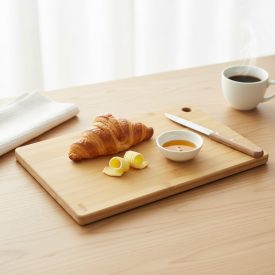Világos bambusz vágódeszka reggeli tálaláshoz croissanttal és vajjal