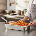 GN 1/1 rozsdamentes edény 40 mm mélyen töltve meleg tésztával, professzionális konyhai környezetben